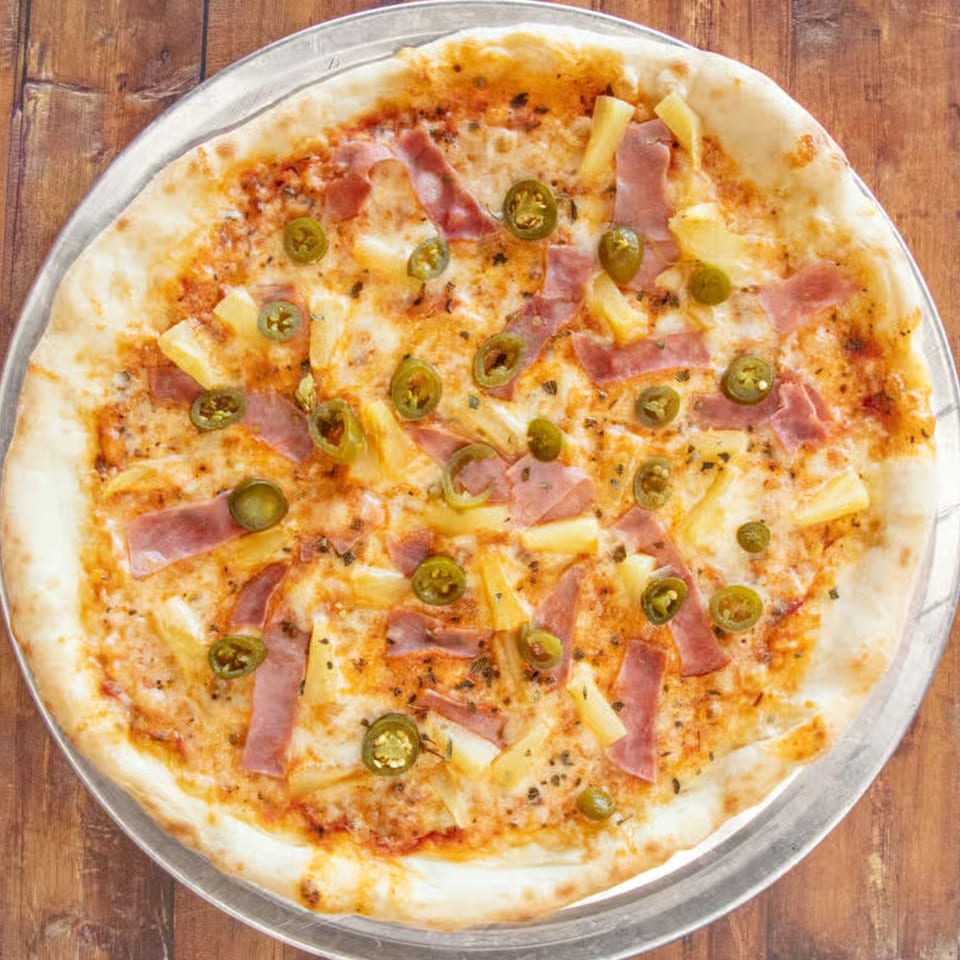 IPIZZA Restaurant's Hawaiian pizza with ham, pineapple, and jalapeños on a metal tray.