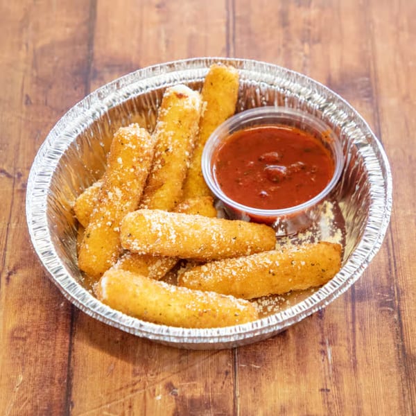 Golden-brown mozzarella sticks, sprinkled with parmesan, in a foil container with a side of marinara sauce.